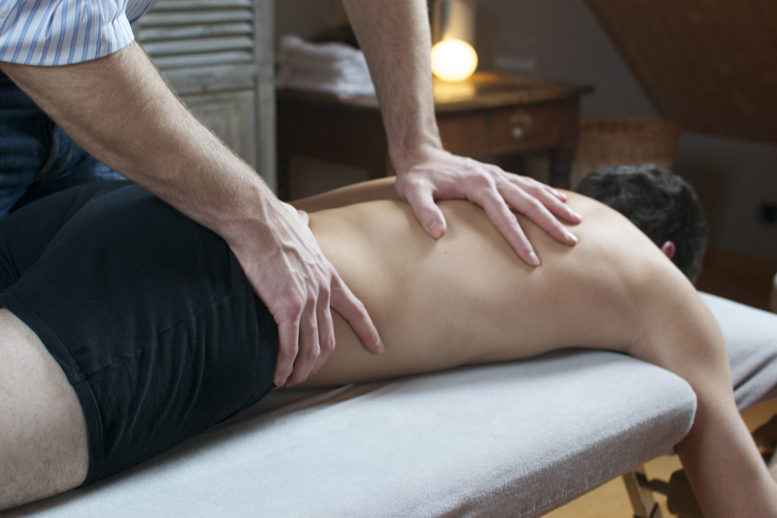 A massage therapist provides a back massage.