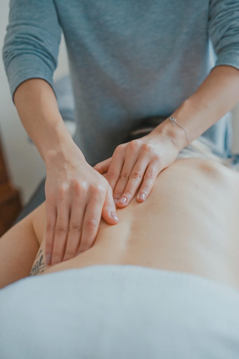 A massage therapist provides a back massage.